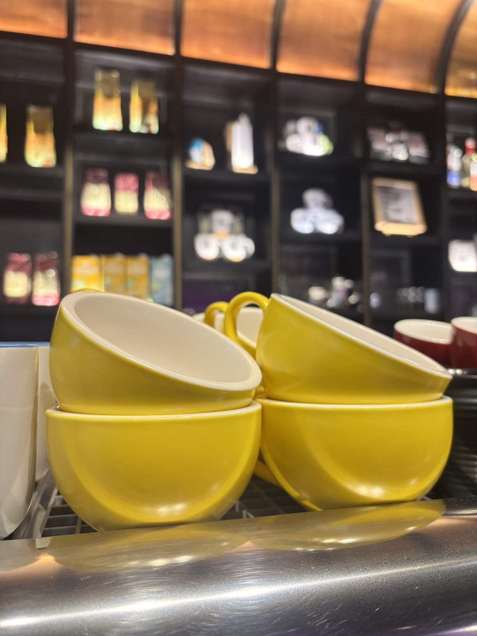 Stacked yellow ceramic cups on a café shelf